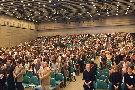 村上氏のメッセージ後、同会議会長の中島秀一氏（日本福音同盟理事長）の祈りに応えて立ち上がって祈る参加者ら