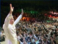 集まった４０００人もの会衆を前に、福音のメッセージを伝えるベニーヒン牧師（BENNY HINN MINISTRIES提供）