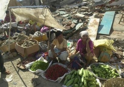 瓦礫の中で野菜を売る被災地の住民たち（AP通信）